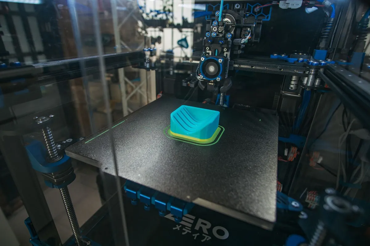 Uzavřená stolní CoreXY 3D tiskárna tiskne modrý model
