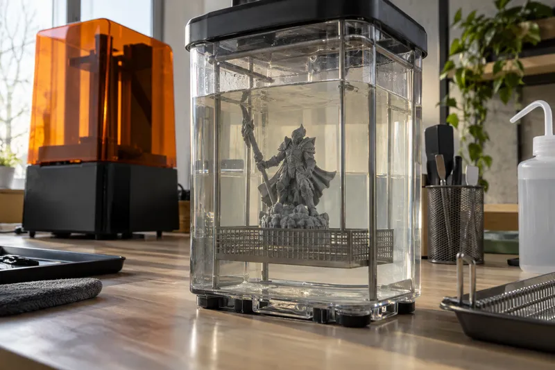 Průhledná nádoba s čisticím roztokem a ponořeným modelem z 3D tiskárny